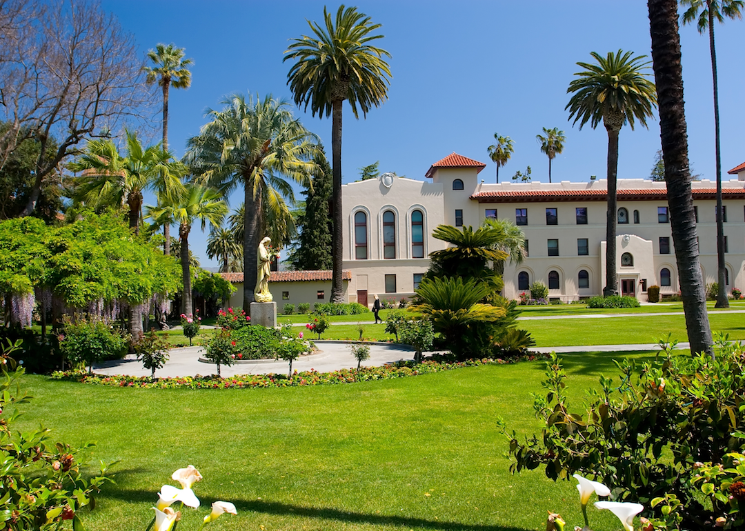 A mission building with palm trees and landscaping.