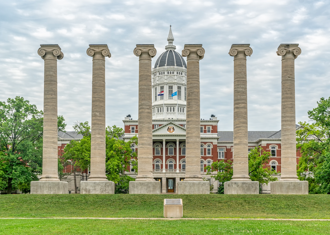 A historic Capitol building with columns in the front lawn.