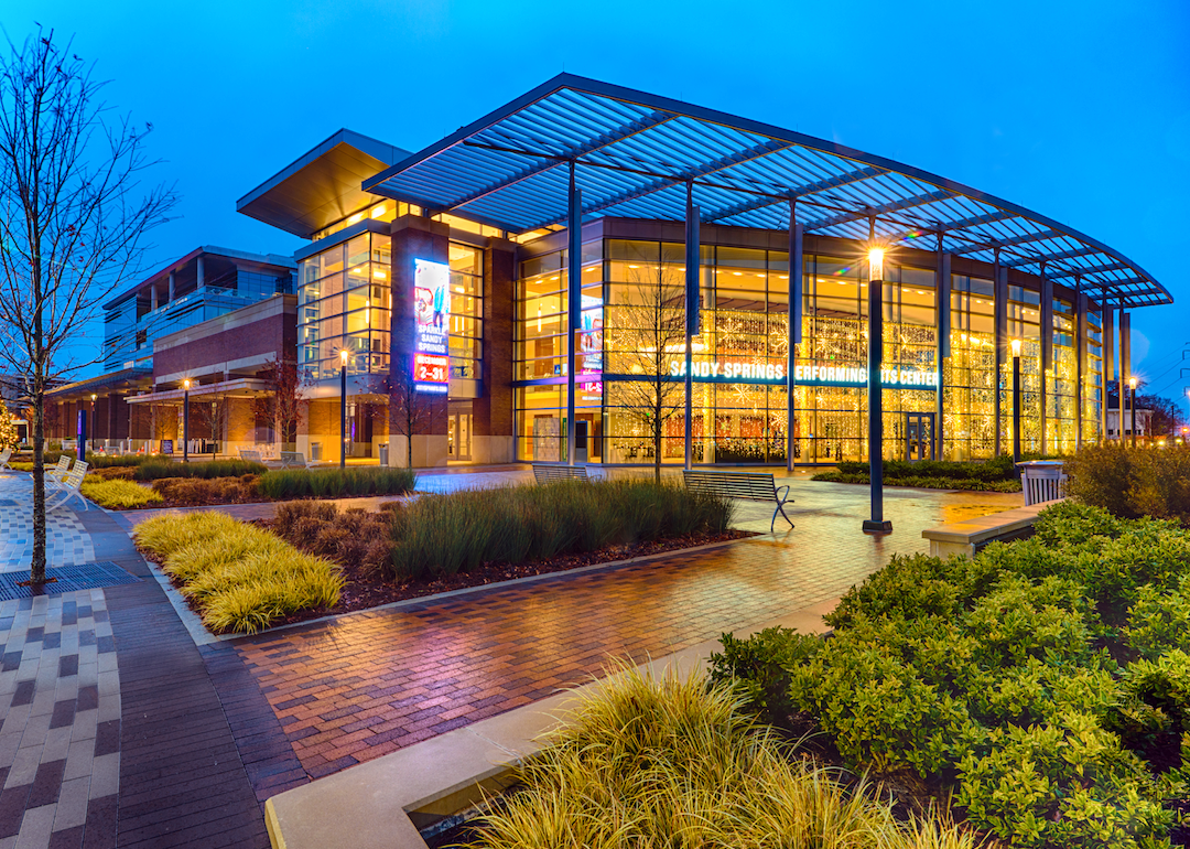 A glass building performing arts center at night.