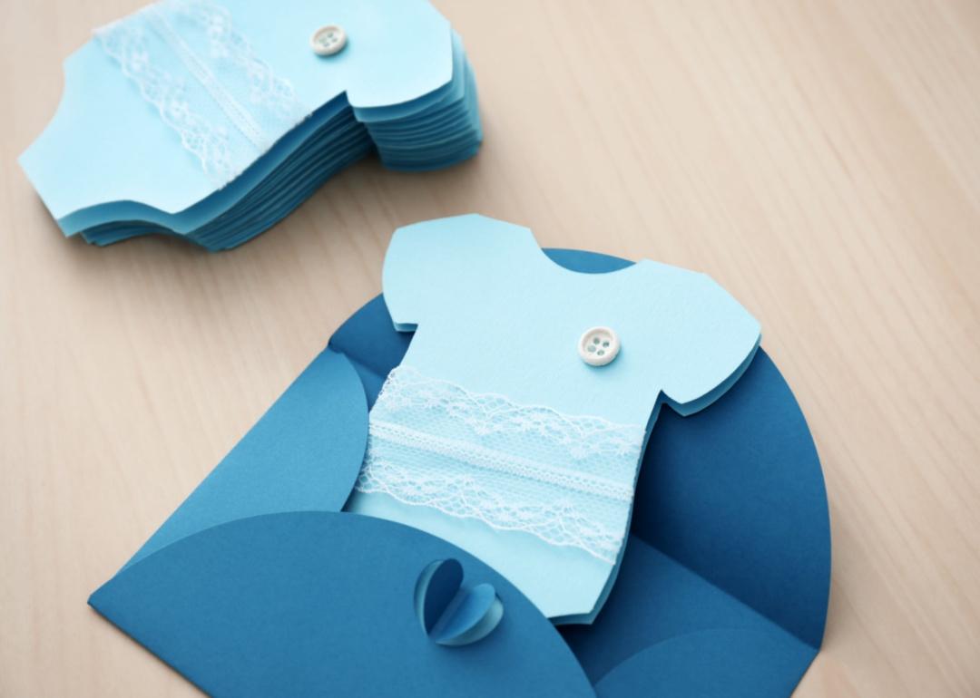 A blue onesie paper invitation.