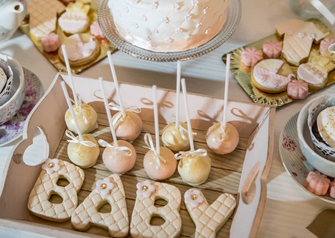 Baby shower sweets, including a cake and cake pops.