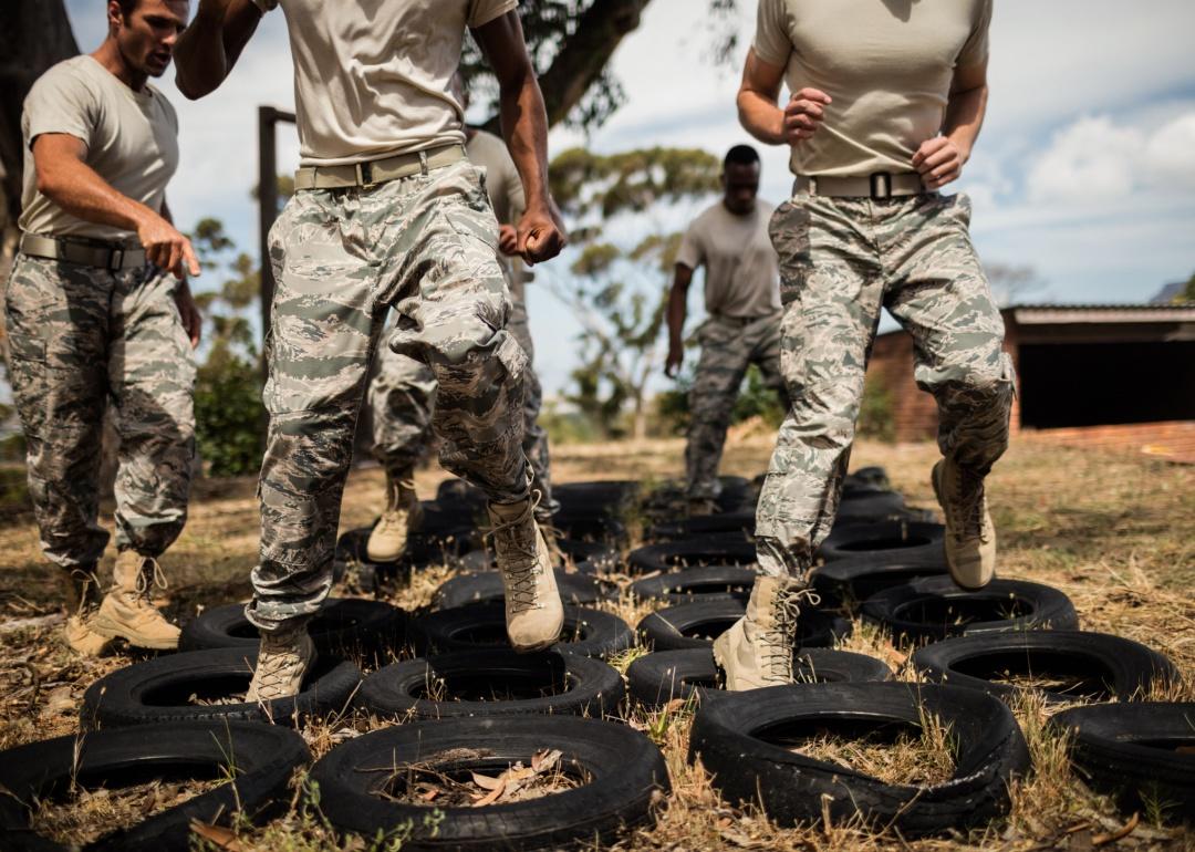 Soldiers jumping through tires for training.