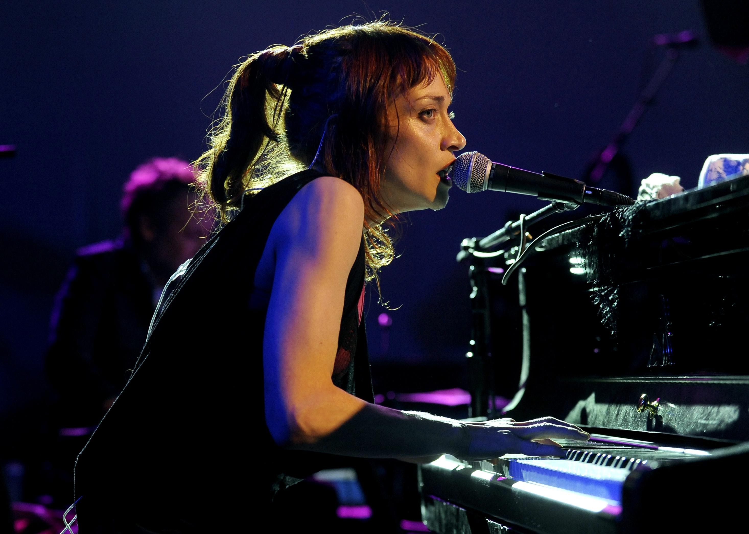 Fiona Apple plays the piano.