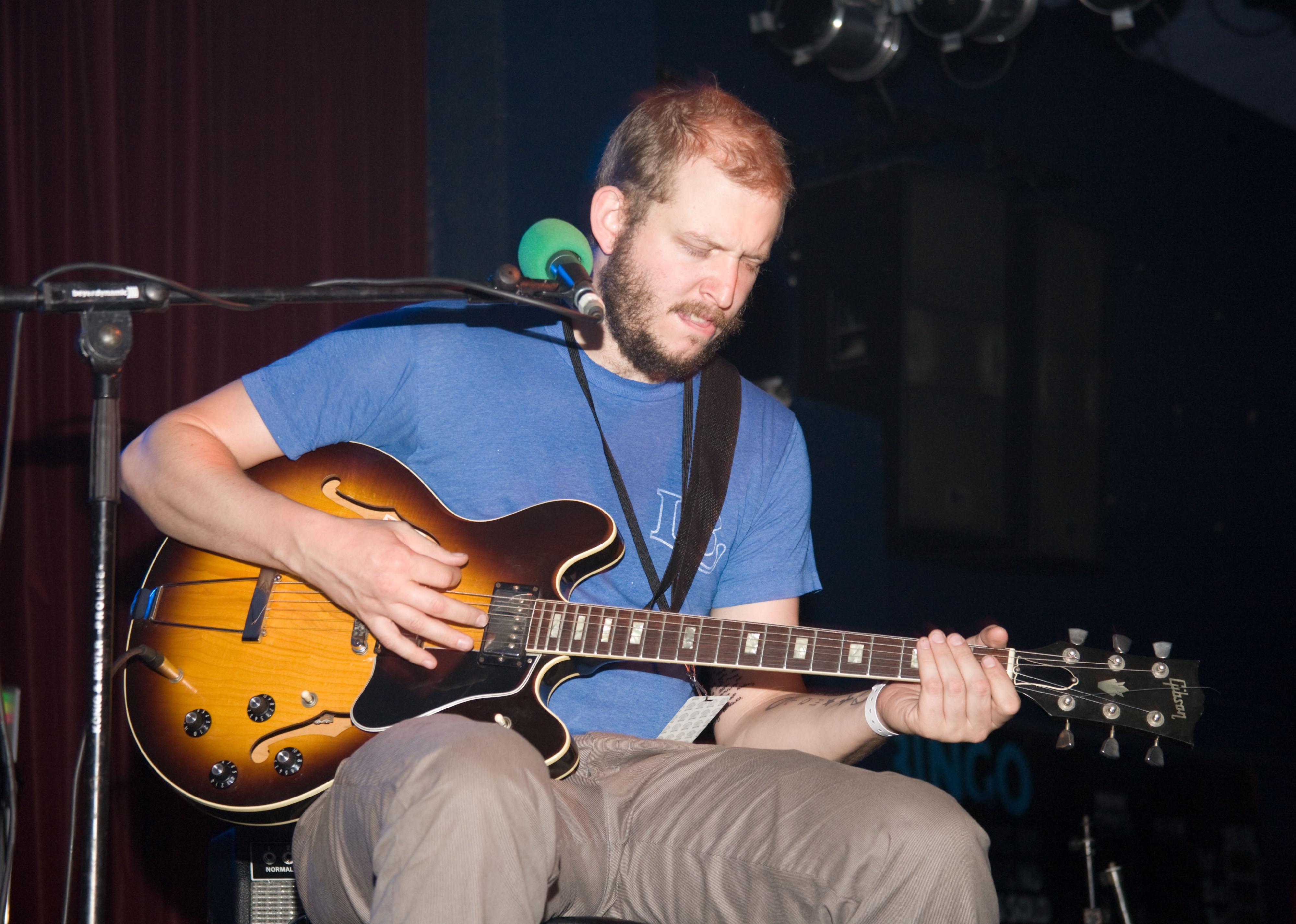 Bon Iver plays a guitar