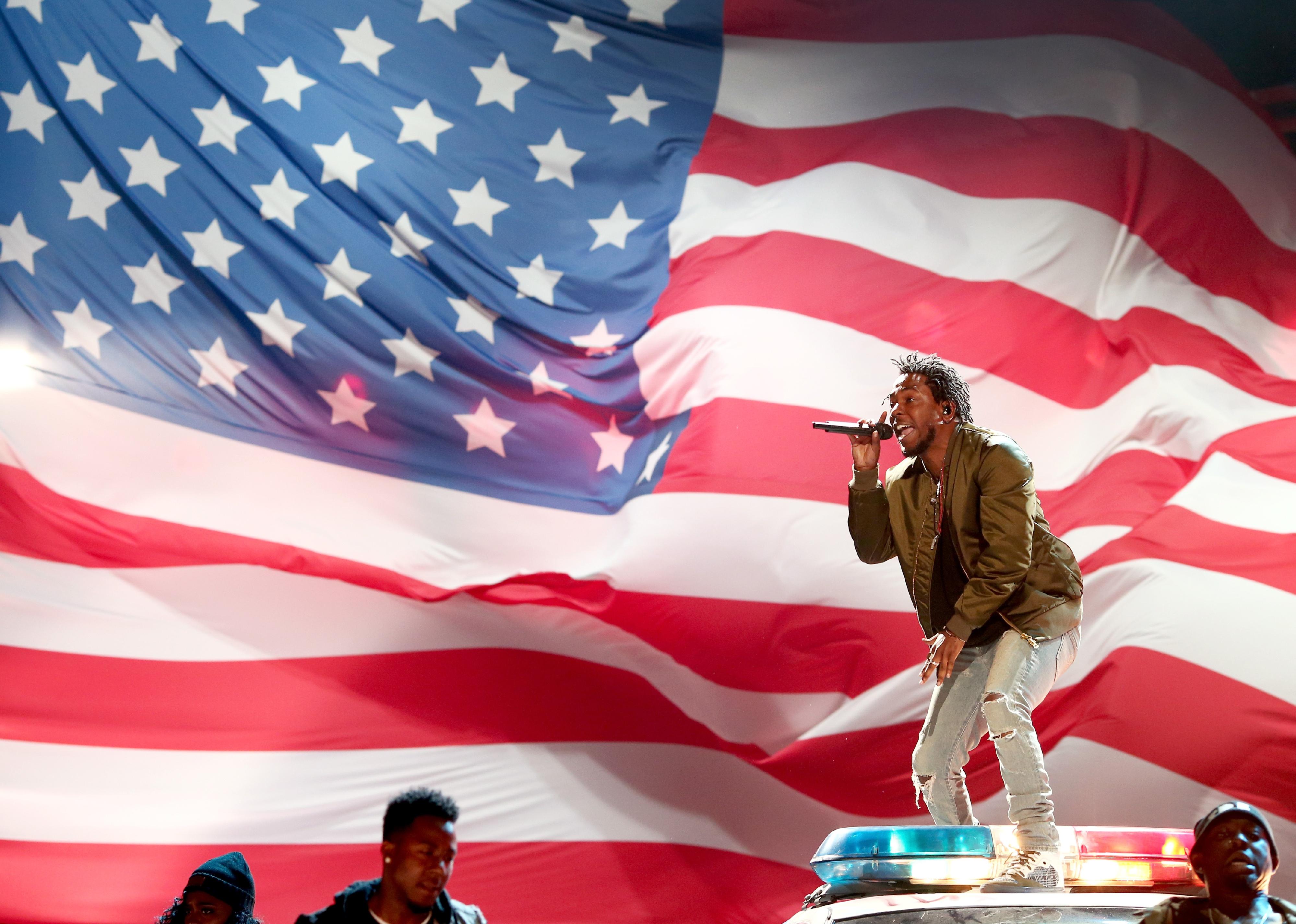 Kendrick Lamar raps in front of an American flag