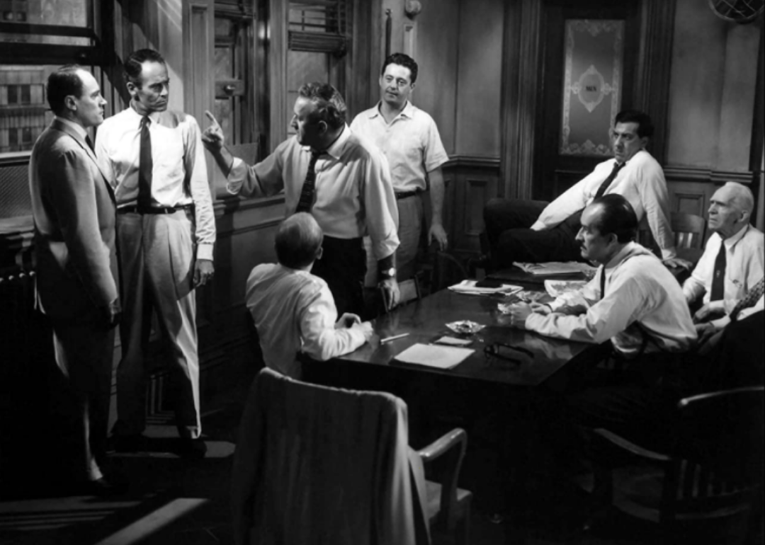 A group of men in white shirts and ties in a room arguing.