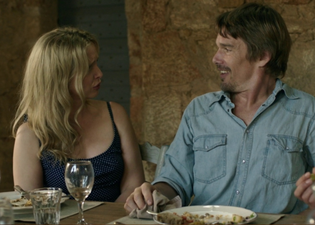 Ethan Hawke and Julie Delpy talking at a dinner table.
