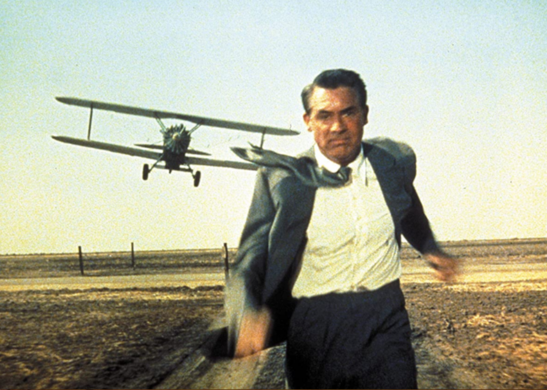 Cary Grant running with an airplane behind him.