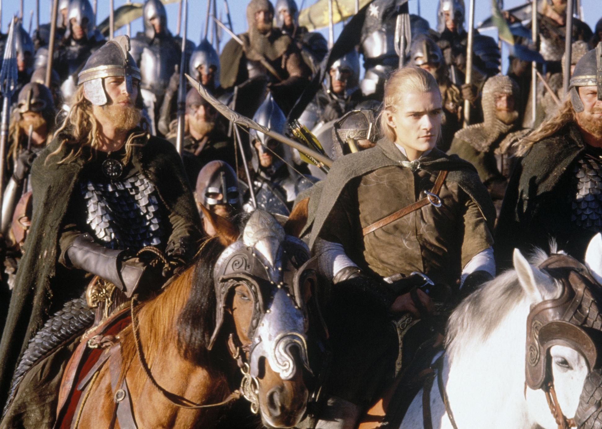 Orlando Bloom with a crowd on horseback with weapons and armor.