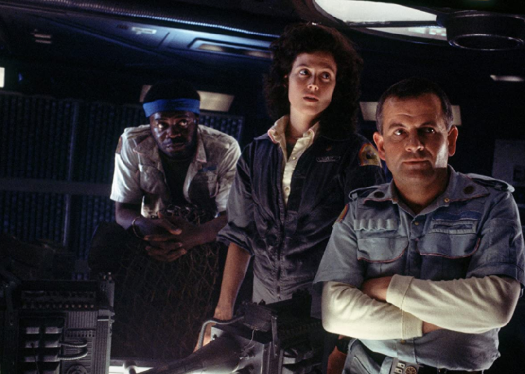 Sigourney Weaver and two men inside a space craft.