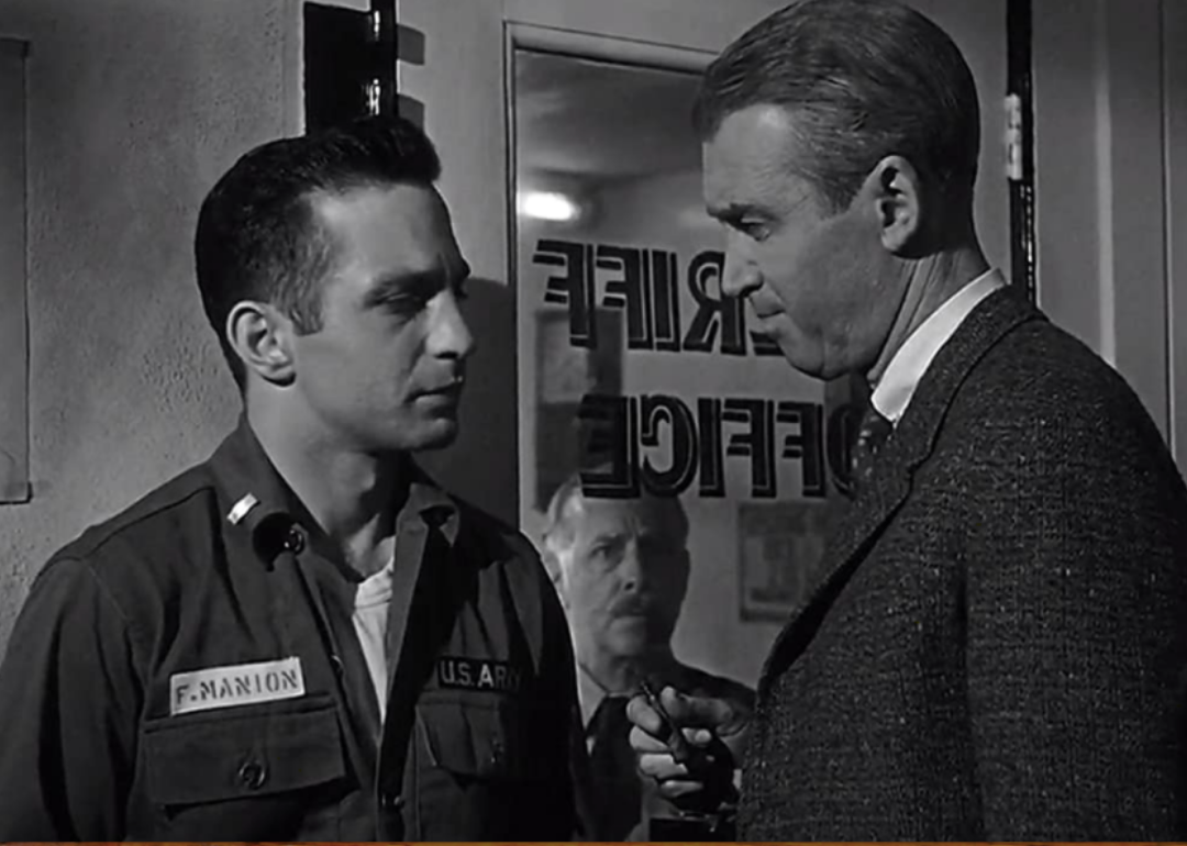 A man in a suit talks with an army soldier at the sheriff office.