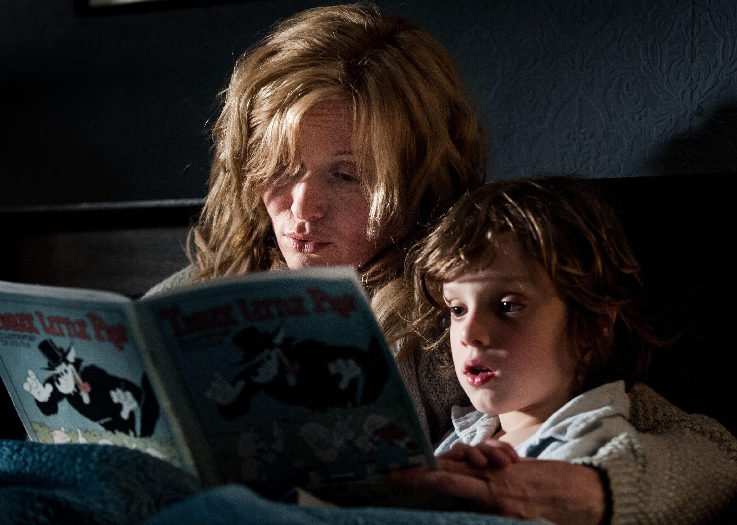 A woman reads a story to her son at bedtime.