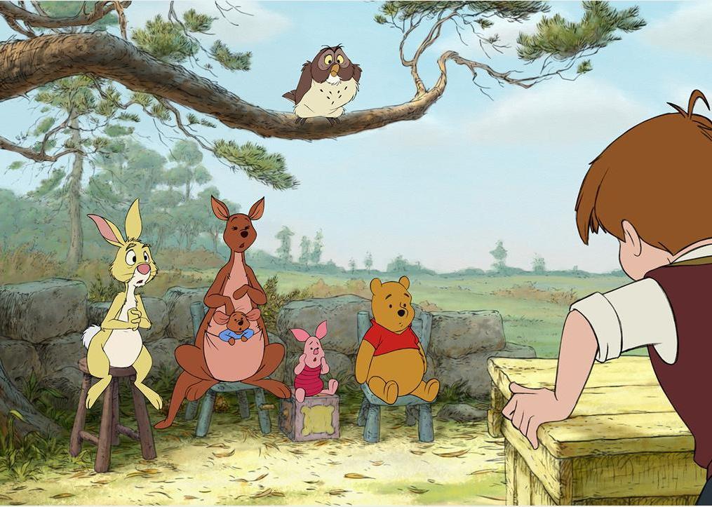 A little boy standing at a podium in the forest talking to a rabbit, kangaroo, pig, bear and an owl.