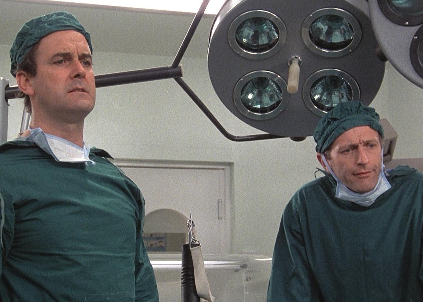 John Cleese and Graham Chapman as surgeons in the operating room.