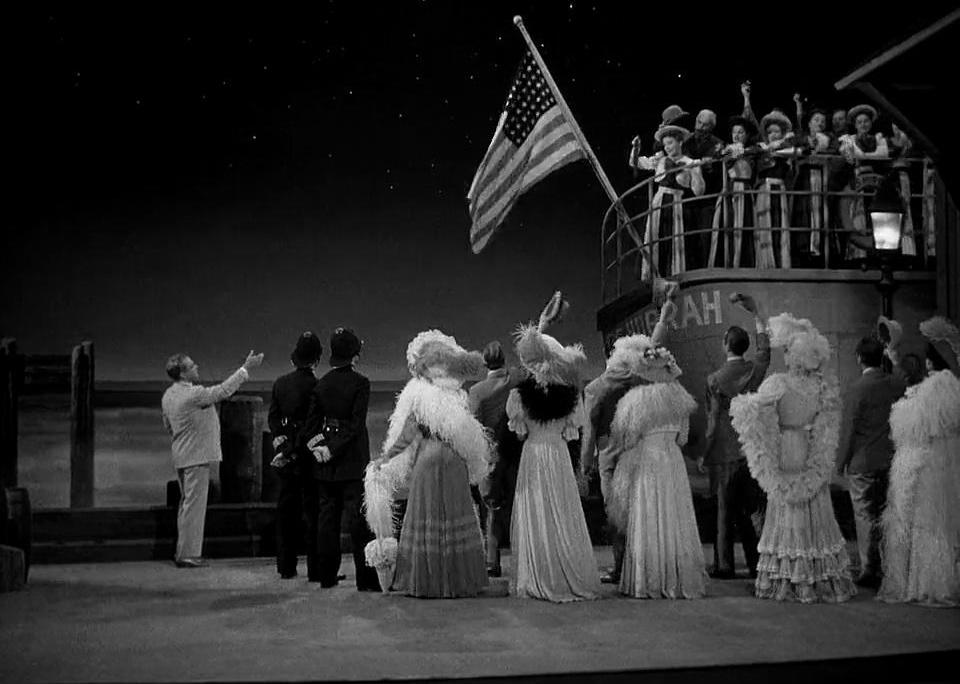 People dressed up and cheering for a crowd on an American ship.
