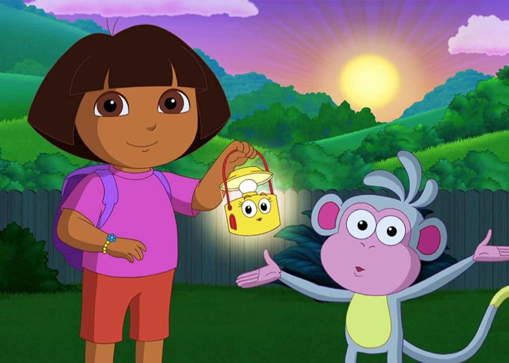 A girl with a lantern standing next to a monkey.