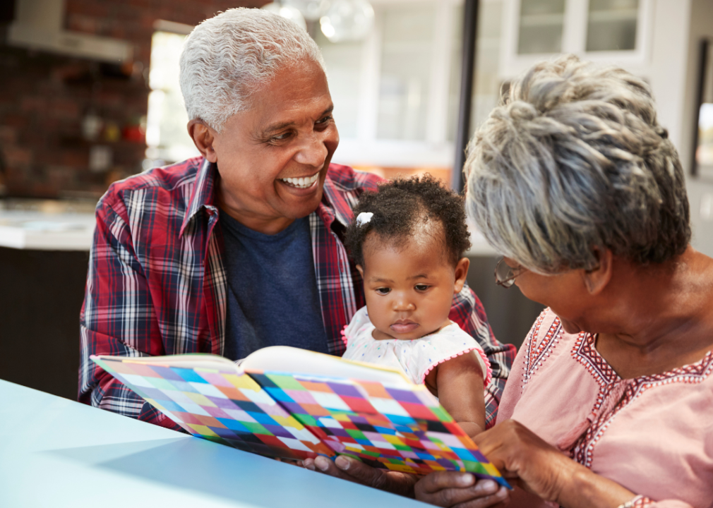 Grandparents reading to a baby.