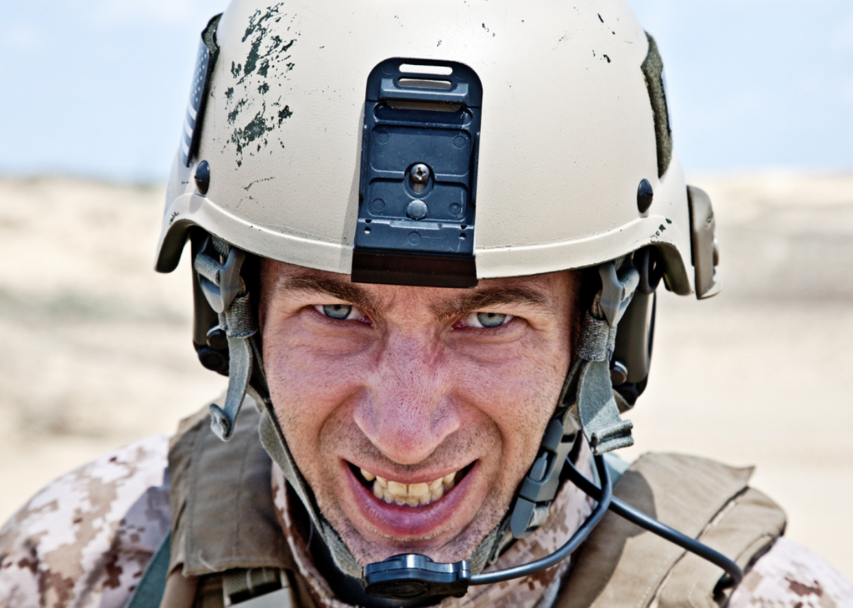 A soldier showing his teeth.