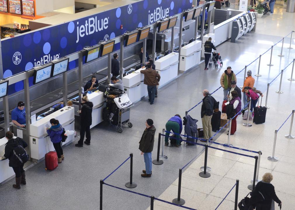 JetBlue passengers stand in lines while waiting for flights.