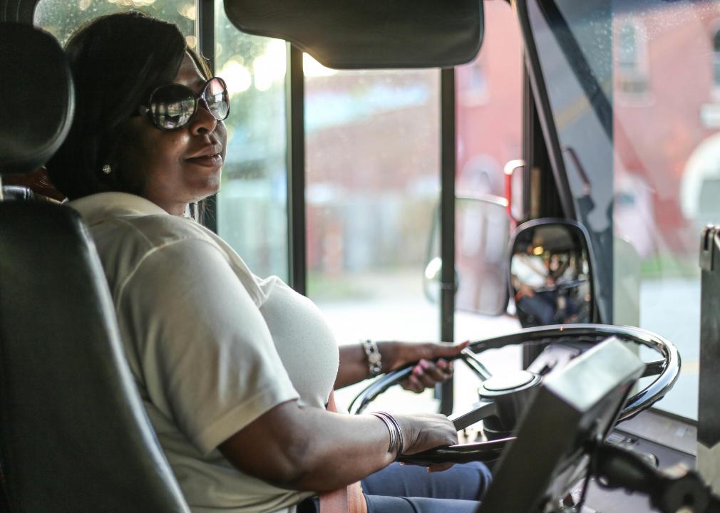 A woman drives a bus. 
