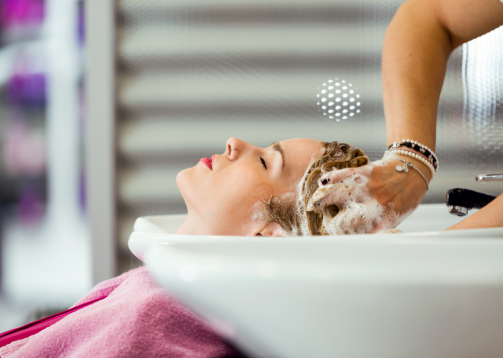 A shampooer washes a client's hair.