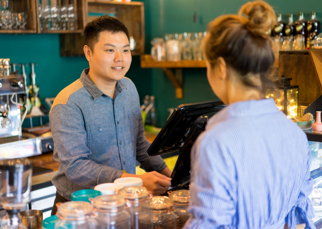 A cashier takes an order from a customer.