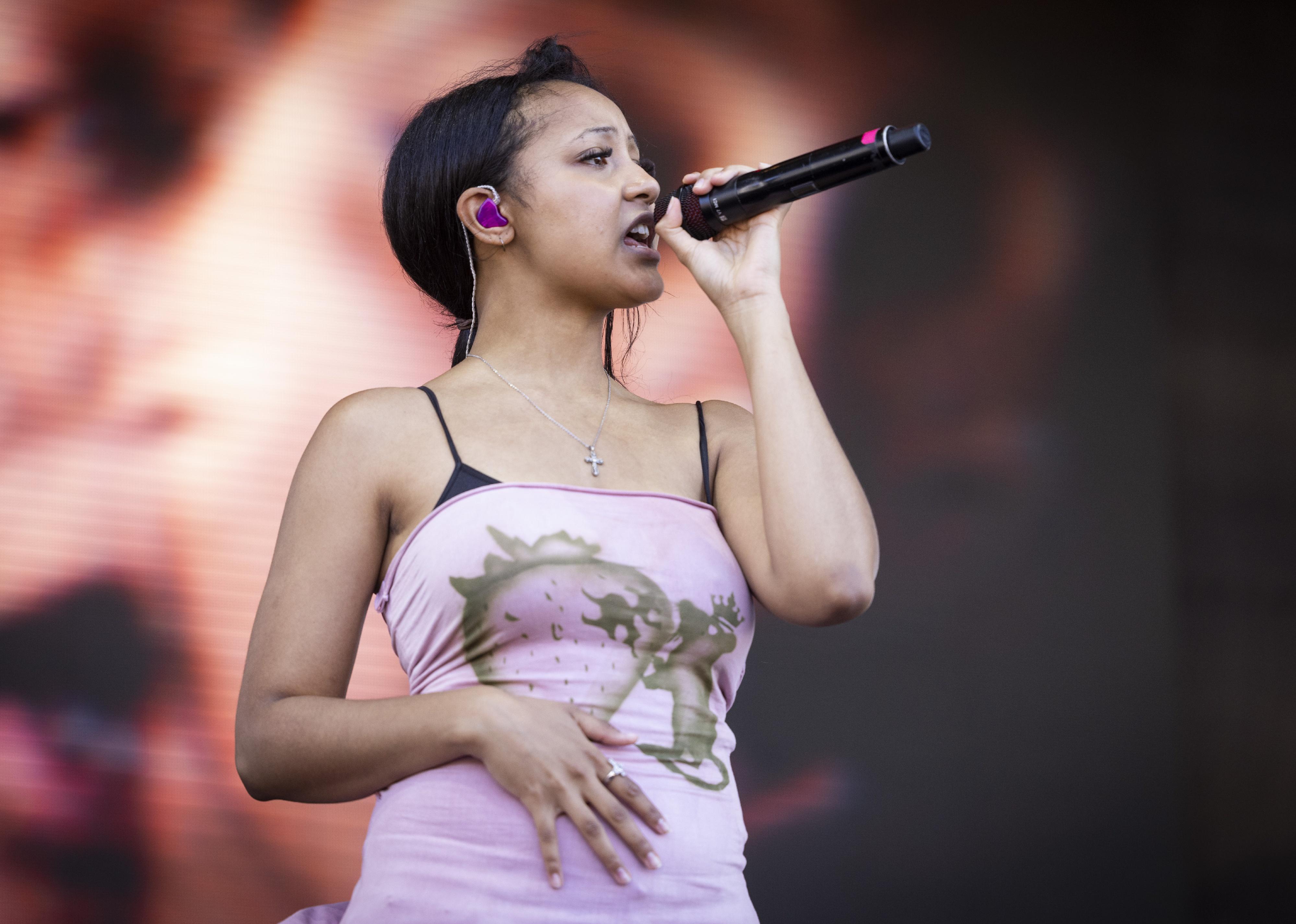 Pinkpantheress performing onstage in a pink top.