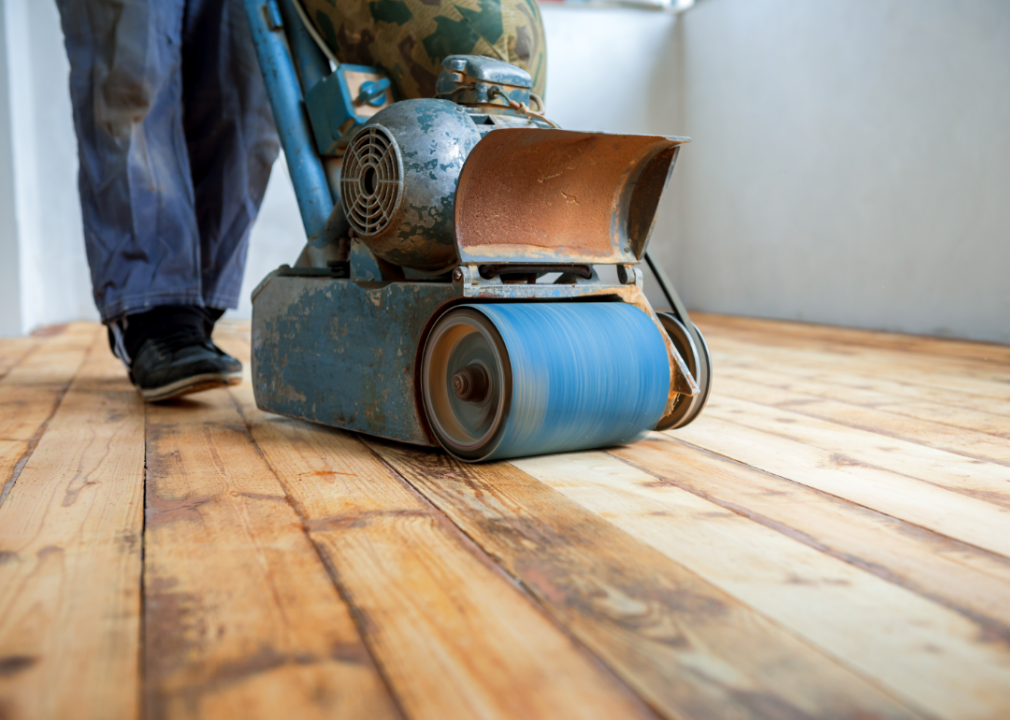 A sander being used on a wood floor.