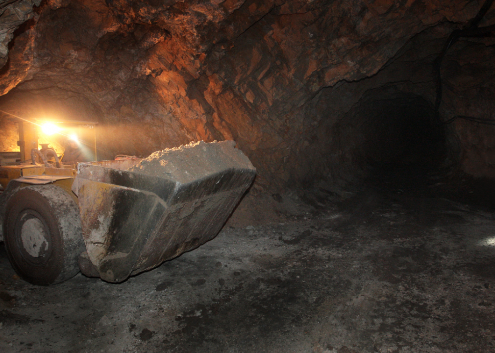 A worker scoops up material in a mine
