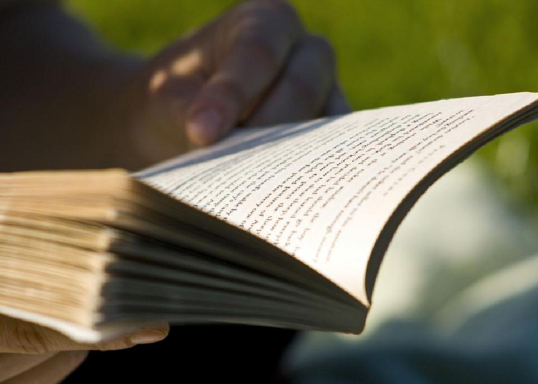 A close up of a person's hands holding an open book. 