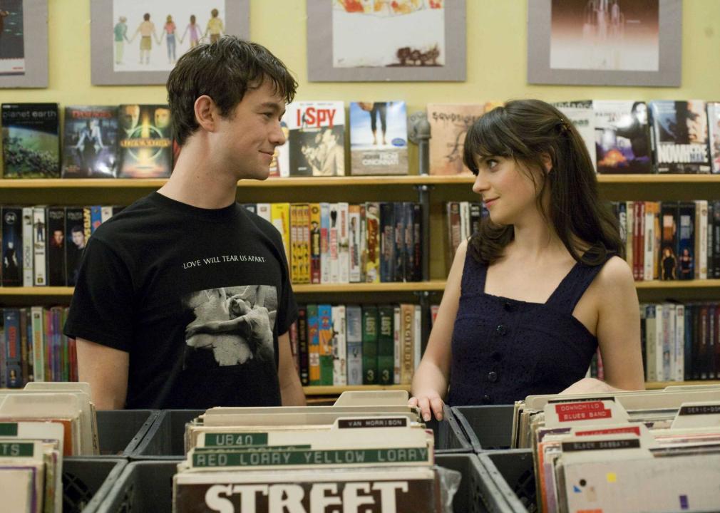 A young man and woman look into each other's eyes in a record store.