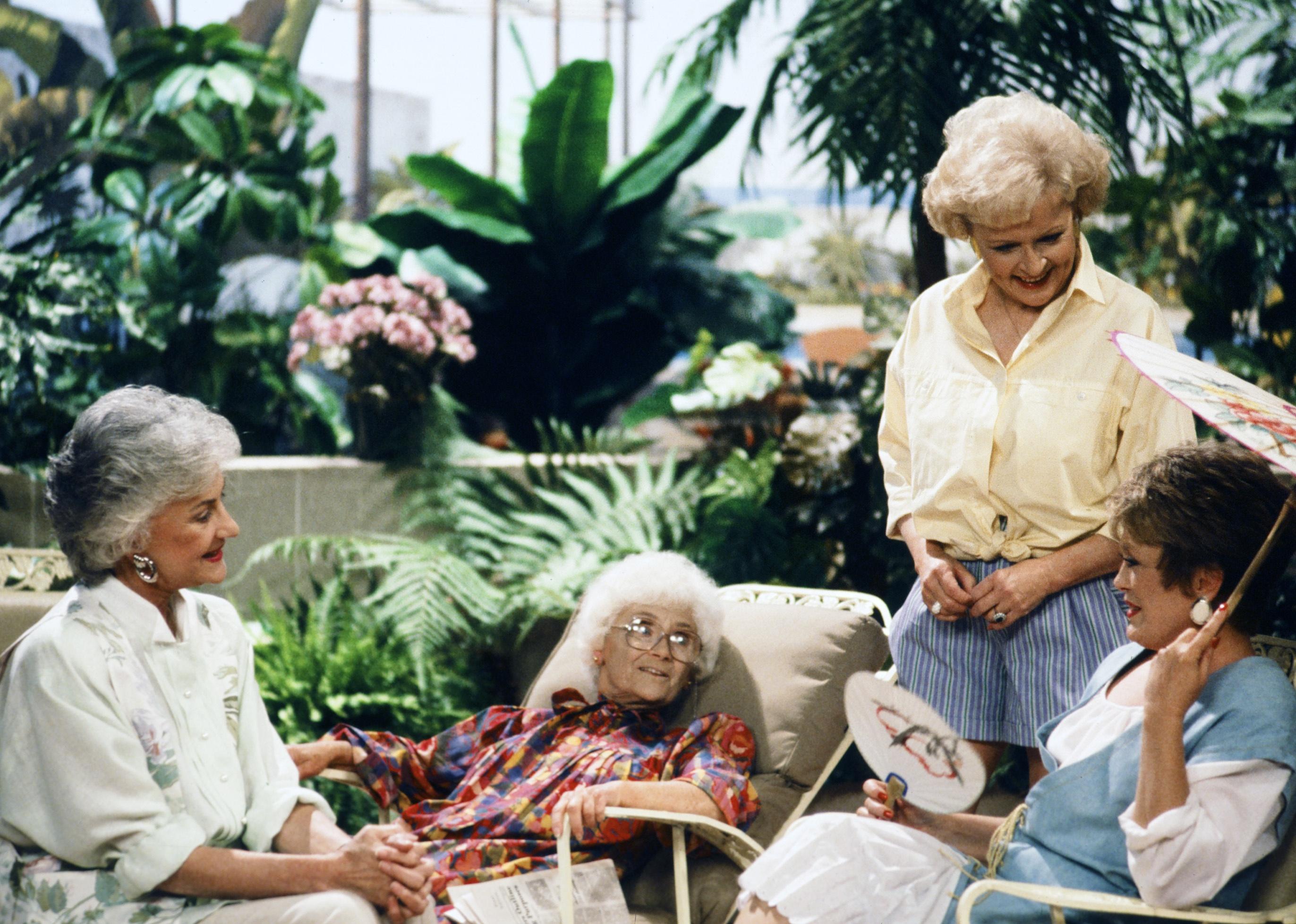 The Golden Girls sitting on a patio talking.