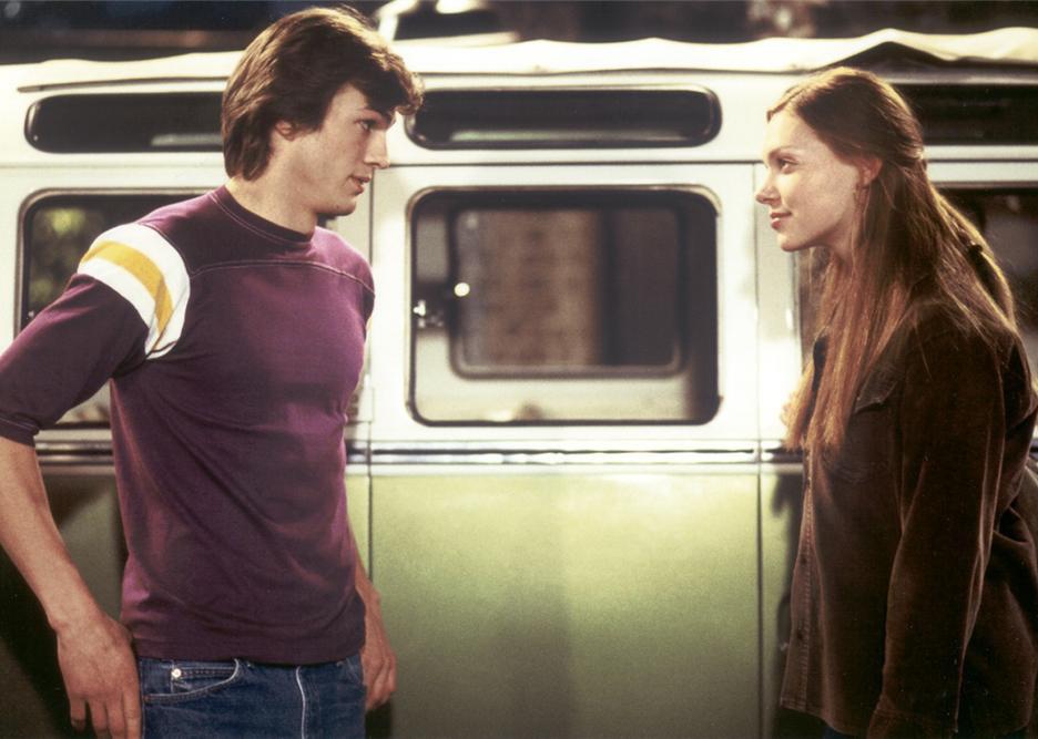 Laura Prepon and Ashton Kutcher's characters in front of a VW van.