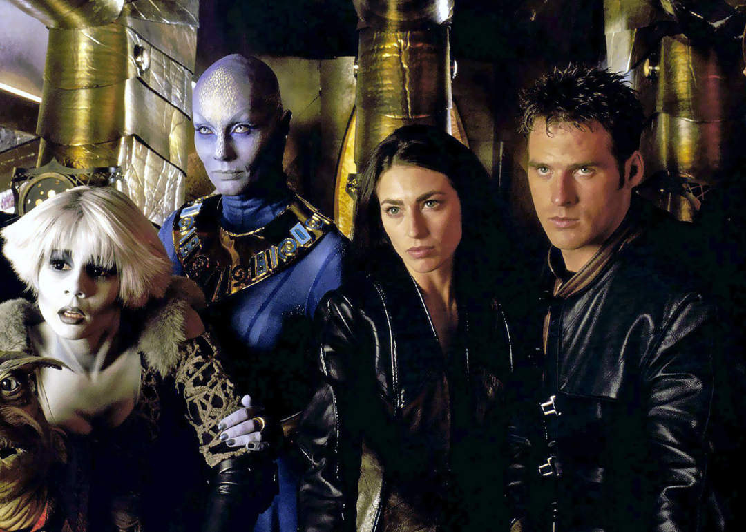 A man and woman in black leather next to two alien like people.