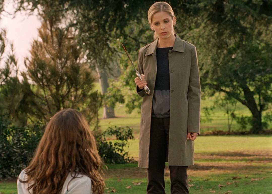 Sarah Michelle Gellar holding a knife while talking to a woman on the ground.