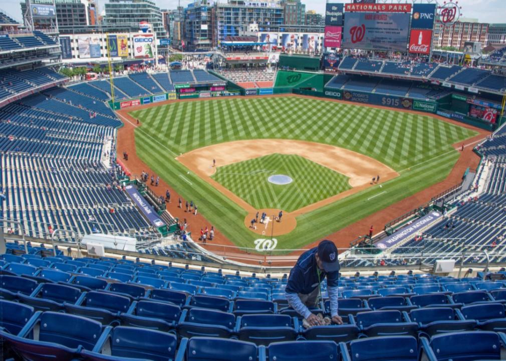 The field from the top of the stadium and an usher cleaning seats before the start of baseball game at Nationals Park in Washington, DC.