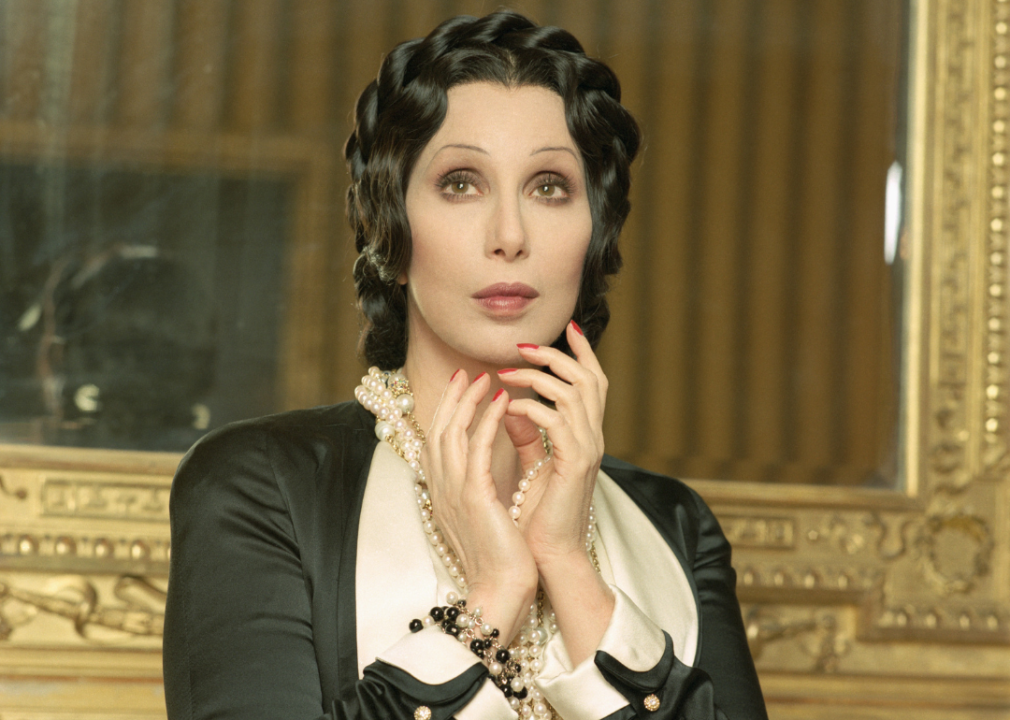 Cher dressed in a silk black and white gown and pearls.