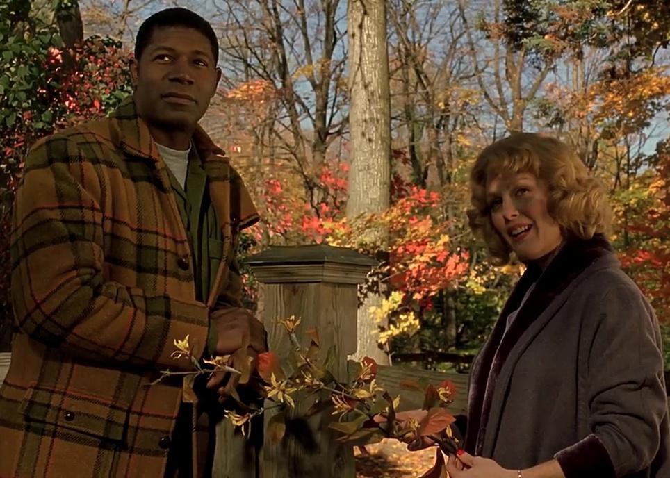 Julianne Moore and Dennis Haysbert talking in front of the fall foliage.