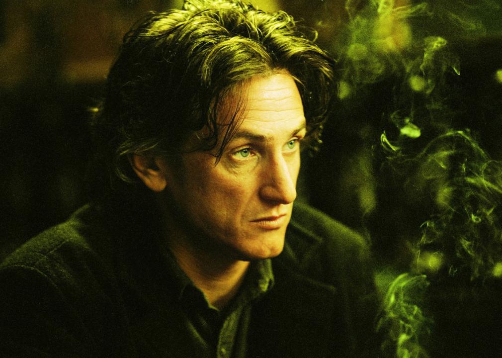 Sean Penn with smoke rising up next to him.