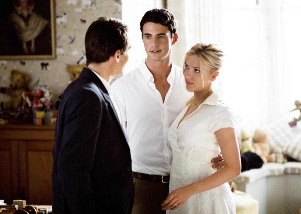 Jonathan Rhys Meyers talks to Matthew Goode and Scarlett Johansson, who are smiling with arms around one another.
