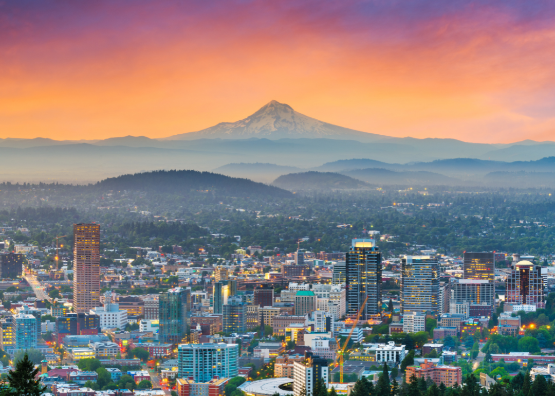 An aerial view of downtown Portland with mountains in the background.
