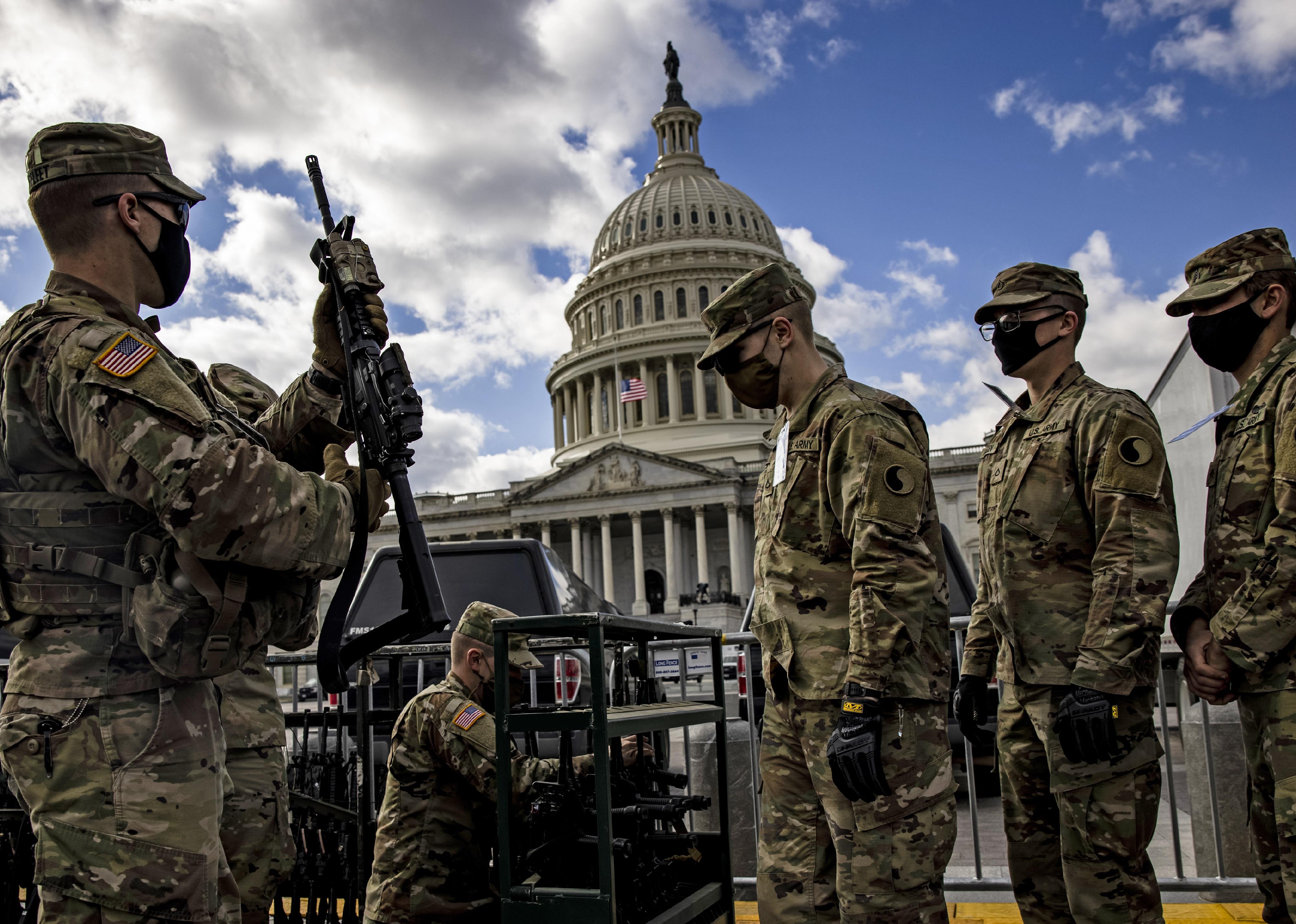 National Guard soldiers are issued rifles in front of the U.S. Capitol.