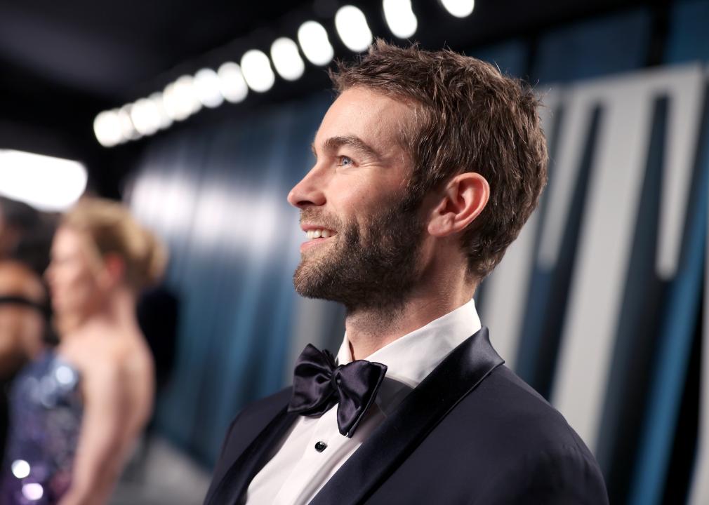 Sideview of Chace Crawford smiling in the spotlight.