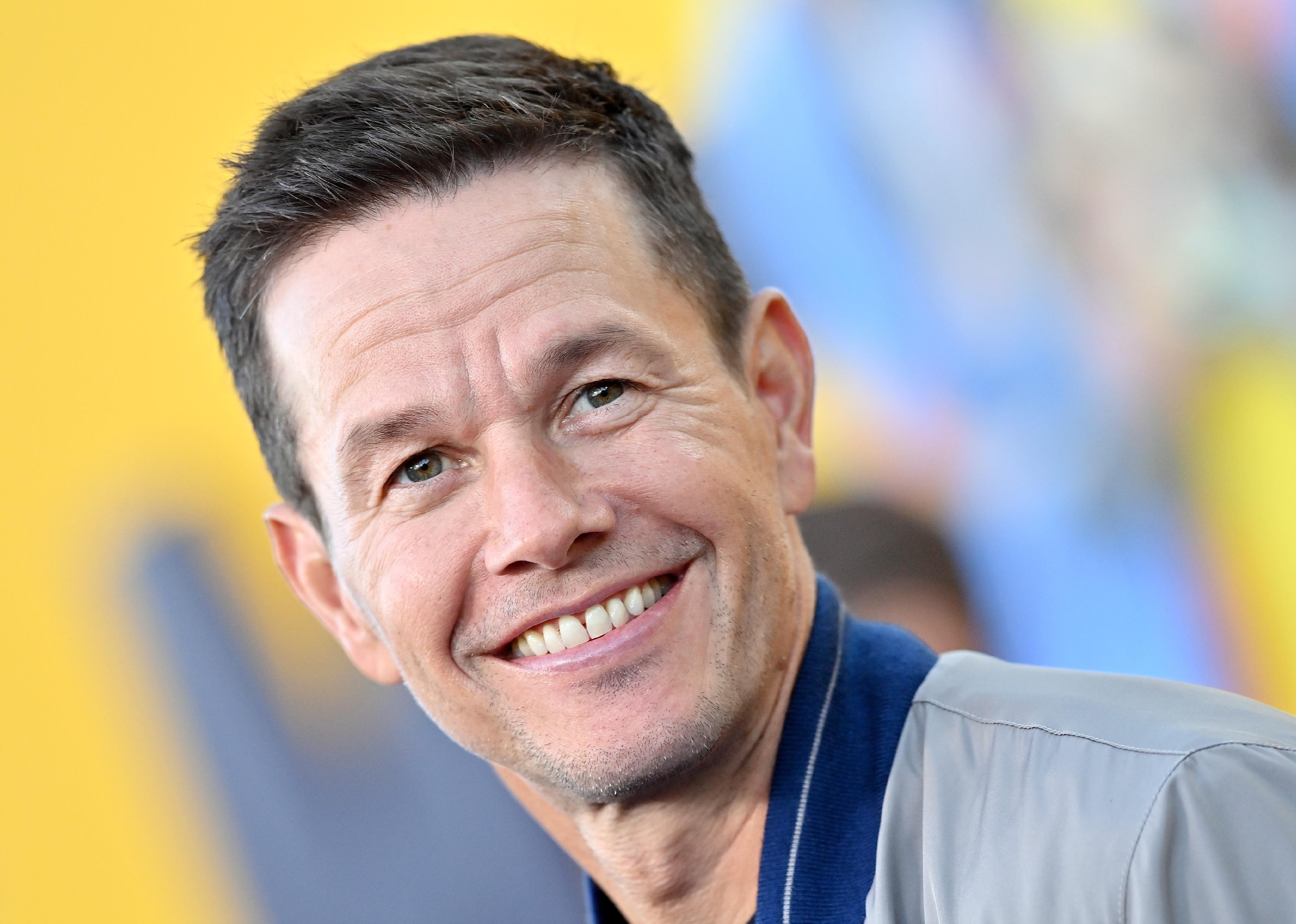 Mark Wahlberg in a grey jacket.