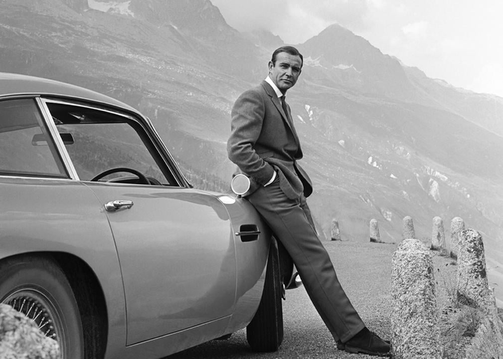 Sean Connery poses as James Bond next to his Aston Martin in Goldfinger.
