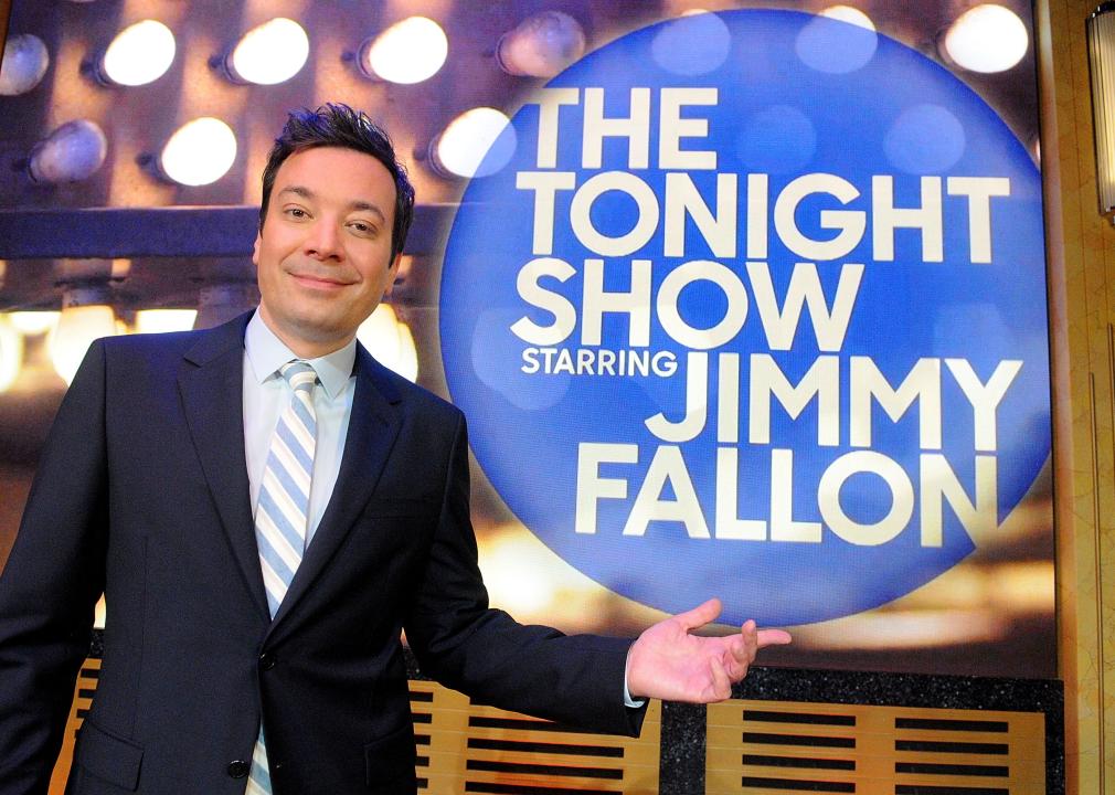 Jimmy Fallon posing in front of the Tonight Show sign.
