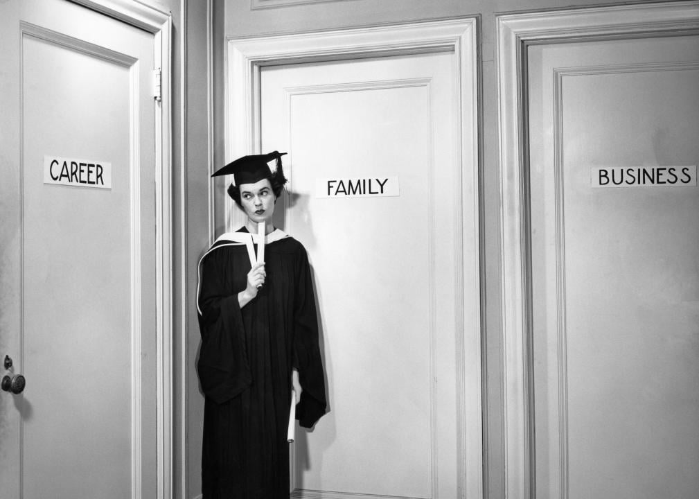 A woman standing in front of three doors reading, "career, family, business".