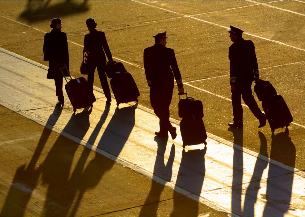 Crew walking on runway to plane.