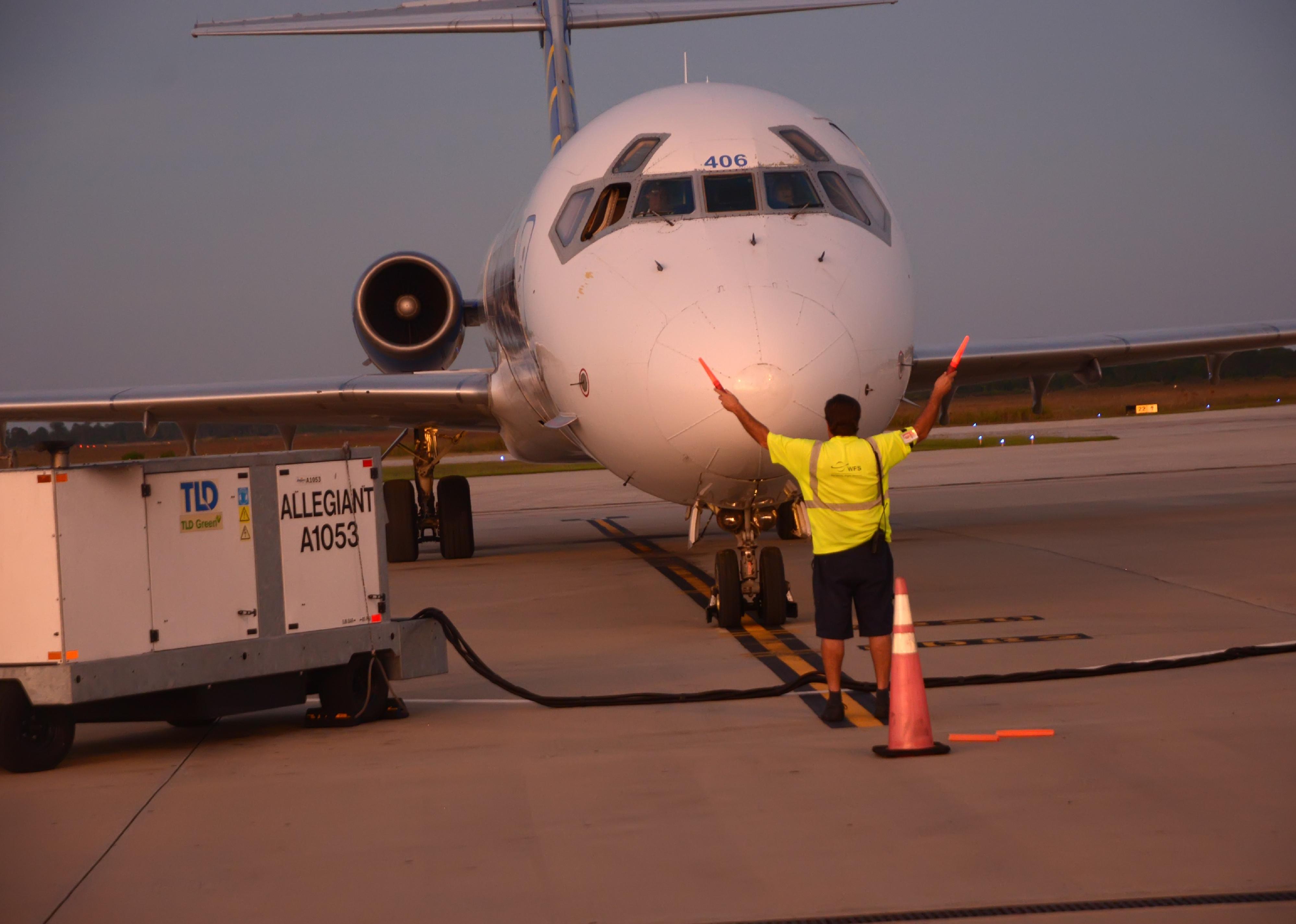 An airport employee directs a plane that just landed at Punta Gorda airport.