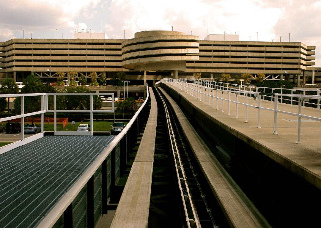 The subway tracks leading to a concrete building at Tampa airport.